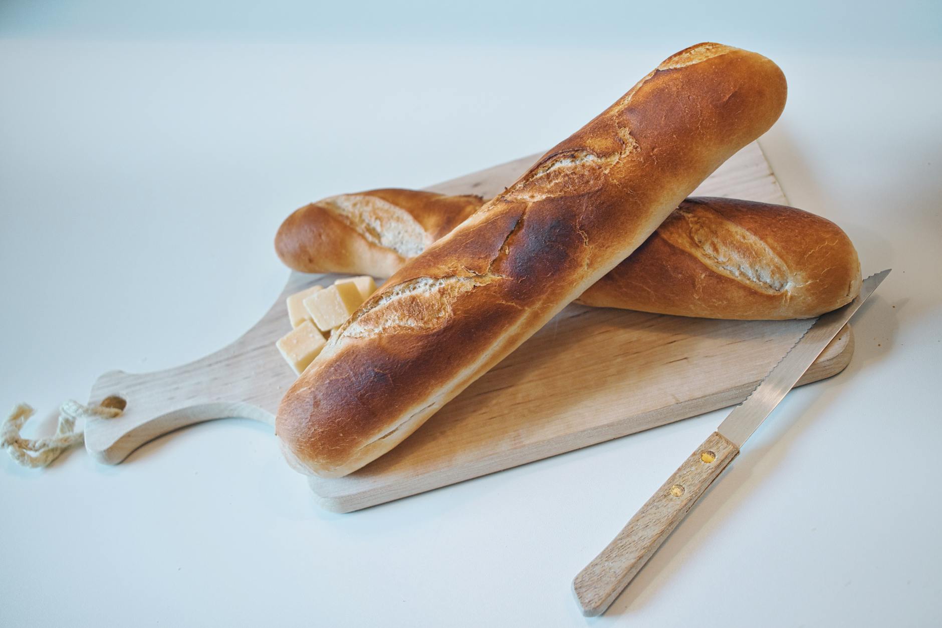 Calories d’une baguette entière : de la tradition blanche à la céréales — baguette fraîche tranchée sur planche en bois