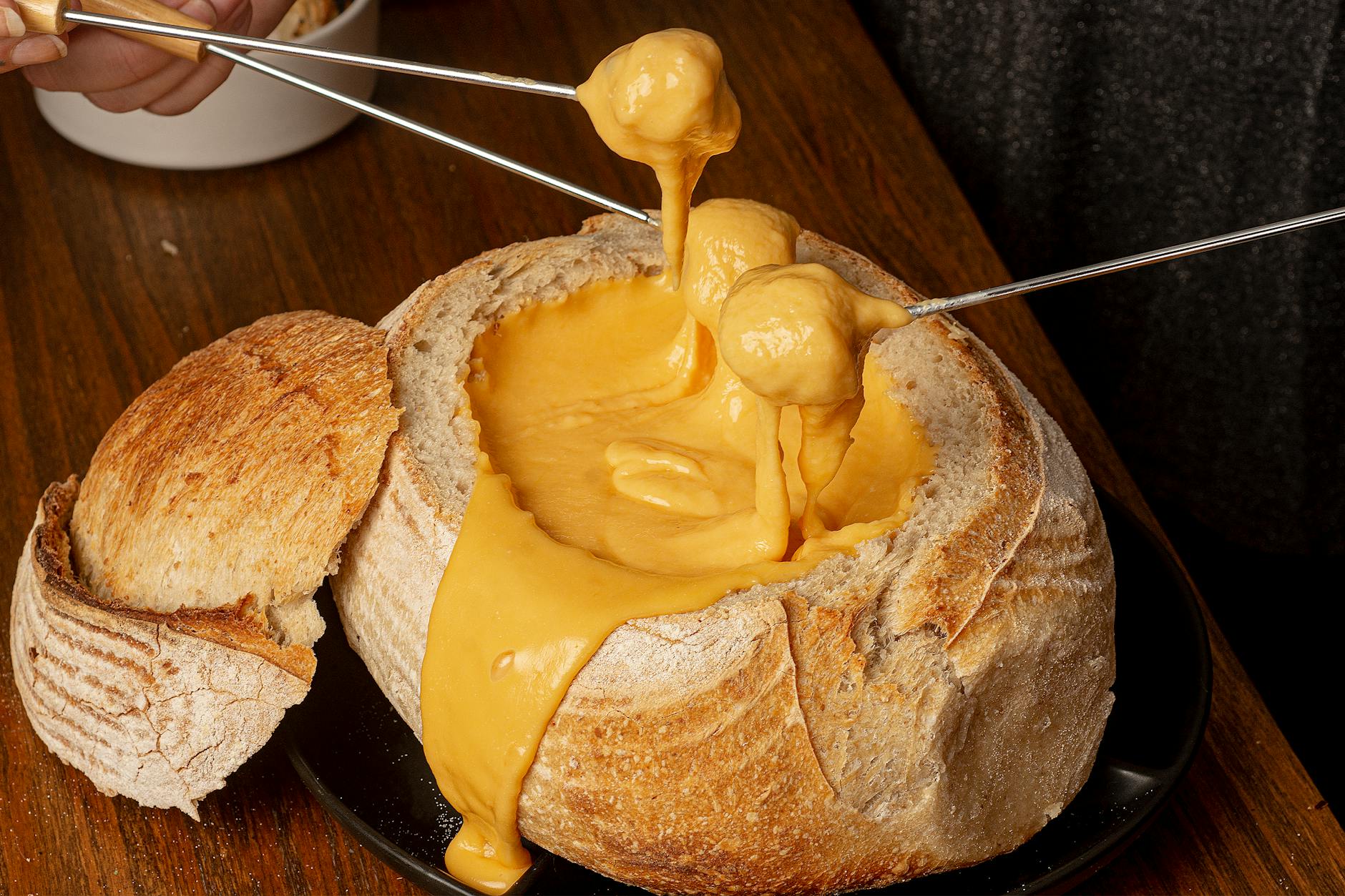 Fondue savoyarde : quelle quantité de fromage par personne pour un repas équilibré — pot de fondue au fromage avec pain